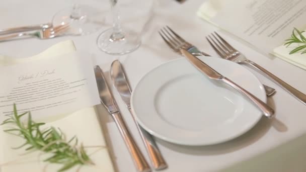 Esküvői asztalra setted ünnepe: lemezek, forks, fehér terítő a virág díszek — Stock videók