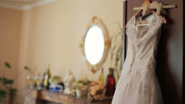 Hermoso vestido de novia listo para la novia colgando en los apartamentos de lujo — Vídeo de stock