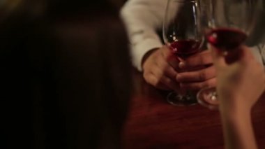 Genç sevgili çift tungur gözlük kırmızı şarap elinde kapatın. Restoranda romantik bir akşam yemeği