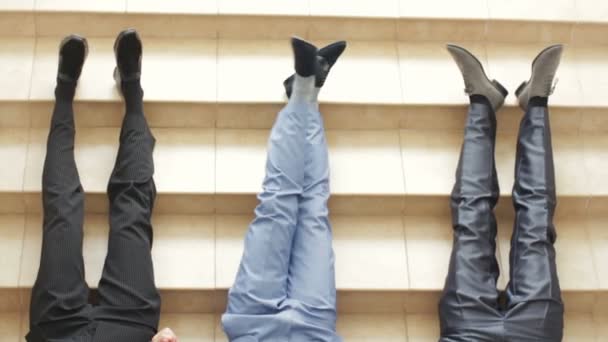 Hombres jóvenes que usan zapatos elegantes en el fondo de escaleras empedradas Tres tipos hipster con zapatos viejos y elegantes y vaqueros típicos . — Vídeo de stock