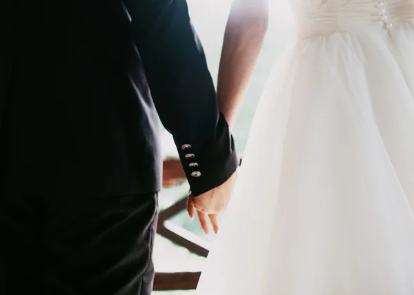 Jeune couple marié tenant la main — Photo