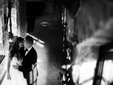 Güzel genç evli çift pencere tarafından yüz yüze kucaklayan ayakta