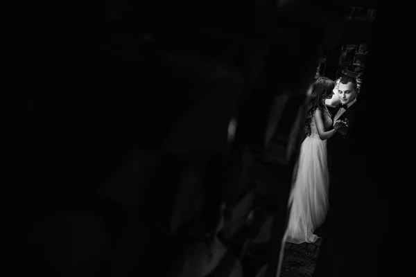Beautiful young married couple in white dancing on the dark background — Stock Photo, Image
