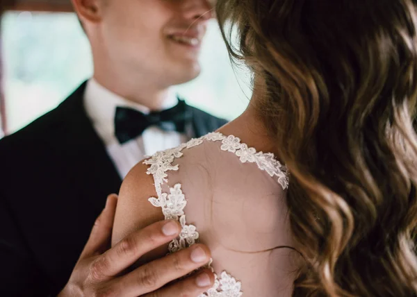 Zwart-wit close-up portret van knappe jonge bruidegom omarmt zijn vrouw die haar haar aanraakt — Stockfoto