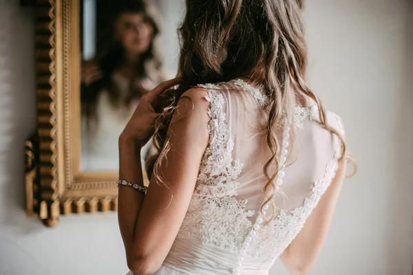 Bella giovane sposa guardando allo specchio — Foto Stock