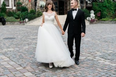 Güzel genç evli çift yürüyüş ve el ele tutuşuyor