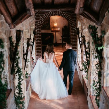 Mutlu yeni evli çift merdivenlerden iniyor ve el ele tutuşuyor