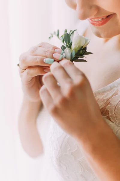 Lovely wedding boutonniere in hands of beautiful bride close up — Stock Photo, Image