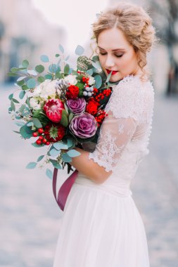 Güzel gelin usulca wer düğün buket arka plan üzerinde antik Avrupa mimarisine sahip tutar