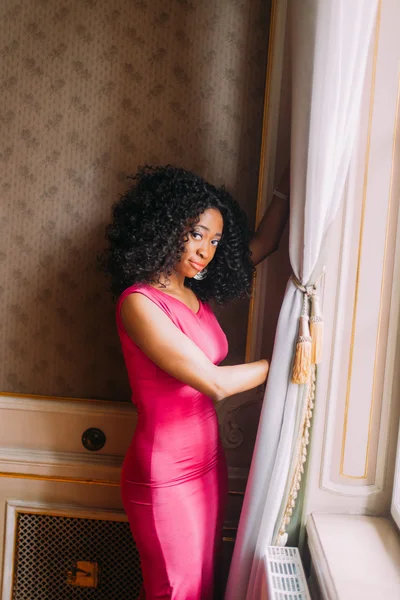 Krásná afroamerické dívka v červených šatech pózuje na luxusní byty — Stock fotografie