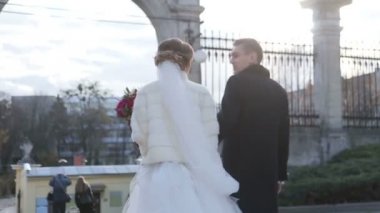 Şehvetli yeni evli çift kilise avluda yürümek. Kamera hareketi yavaş hareket