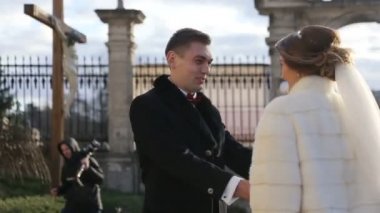 Güzel esmer gelin gelinlik ve yakışıklı damat yumuşak Kilise'nin kucaklayan. Kamera hareketi yavaş hareket