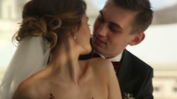 Bella giovane coppia sposa e sposo in un abito da sposa al sole teneramente guardando ciascuno e baciare. Amore girato al rallentatore da vicino — Video Stock