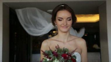 Çiçek buketi ve kamera için poz uzun peçe ile lüks beyaz elbise mutlu muhteşem gelin. Düğün günü