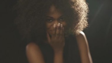 Güzel egzotik utangaç genç siyah kadın elle yüz kapakları ve flört