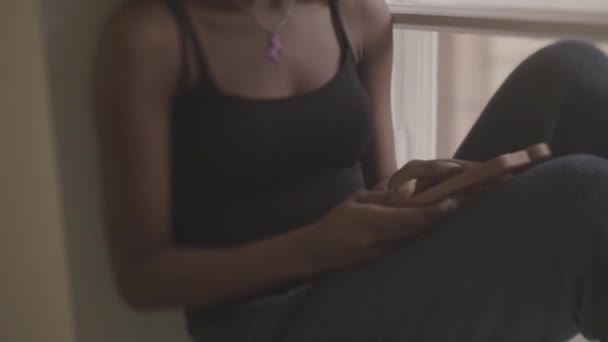 Gorgeous afrikanska kvinnor sitter på windowsil och eftertänksamt ser på bilden i ram. Flicka bruten Hearted — Stockvideo