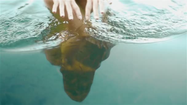 Belle fille nue reflet dans l'eau bleue pure. Magnifique femme touche doucement la surface de l'eau et les petits poissons nagent à ses jambes. Jeune Nymphe du lac Synevir dans les Carpates — Video