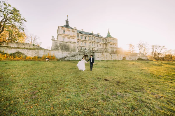 Brautpaar am Hochzeitstag beim Spaziergang im Freien auf dem Burggelände — Stockfoto
