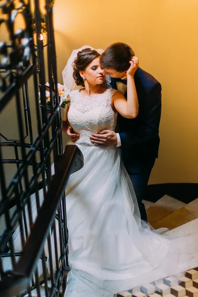 Yeni genç evli çift merdivenlerde ayakta kucaklayan