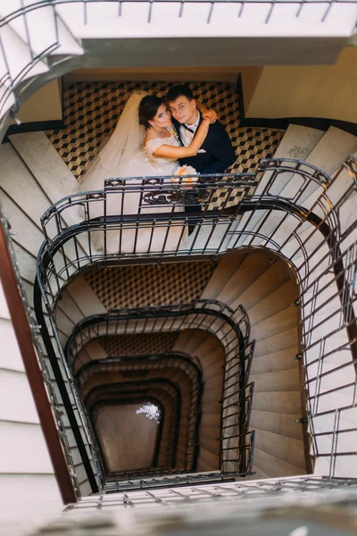 Νεαρό παντρεμένο ζευγάρι στέκεται πρόσωπο με πρόσωπο στις σκάλες και κρατώντας τα χέρια — Φωτογραφία Αρχείου
