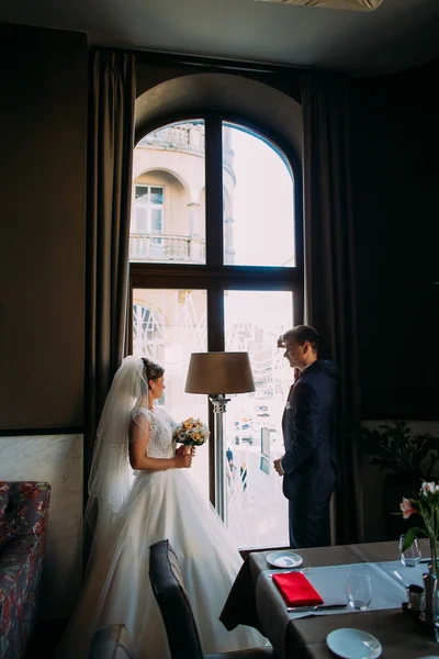 Schönes junges Ehepaar, das von Angesicht zu Angesicht am Fenster steht — Stockfoto