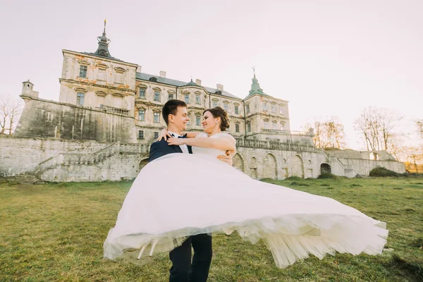 Bella giovane sposa e bello sposo ballare all'aperto vicino vecchio palazzo al tramonto — Foto Stock