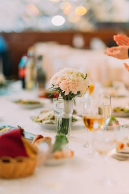 Fantezi masa bir düğün yemeği için setted ve vazo çiçeklerle süslenmiş