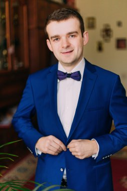 Yetişkin sağlam adam kameraya seyir pencere yakınındaki mavi takımı düğme