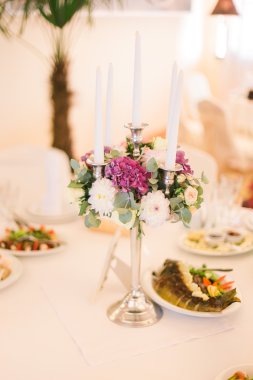 Festive wedding table setting with pink flowers, glasses and candles