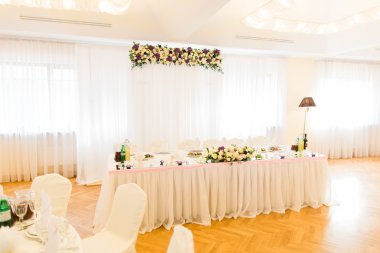 Düğün kutlamak için beyaz çiçekler, gözlük ve mumlar restoran ile döşenmiş