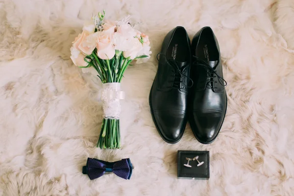 Grooms ochtend. Bruiloft accessoires. Blauwe vlinder-stropdas, manchetknopen, ringen en boeket van witte rozen — Stockfoto