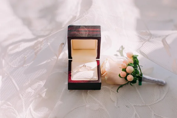 Anillo de boda de oro en caja y flores de rosa en el lateral . — Foto de Stock
