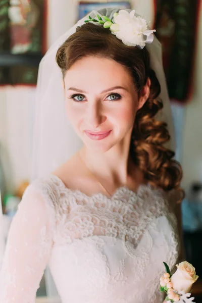 Primer plano retrato de novia con estilo feliz en vestido blanco de lujo y velo posando con rosa cerca de la ventana —  Fotos de Stock