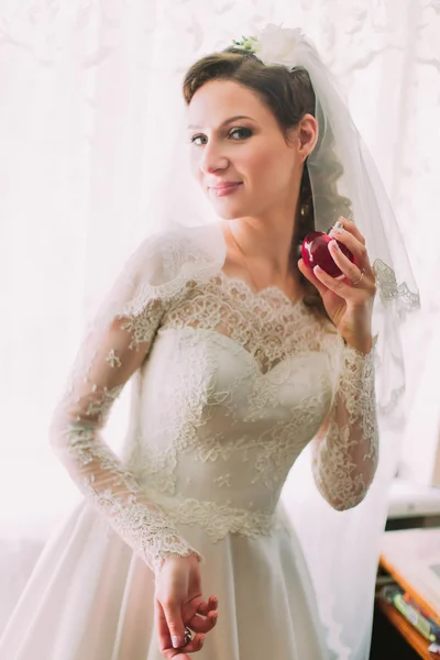 Bella sposa in abito vintage spruzzando profumi primo piano vicino alla finestra — Foto Stock