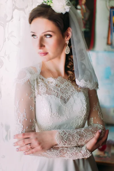 Retrato de mulher jovem com cabelo grosso chique, vestindo vestido branco olhando para a janela, em perfil — Fotografia de Stock