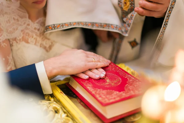 Bride and groom are holding hands on Bible — ストック写真