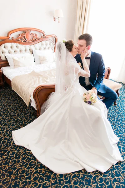 Romantischer Kuss glückliche Braut und Bräutigam im Schlafzimmer am Hochzeitstag — Stockfoto