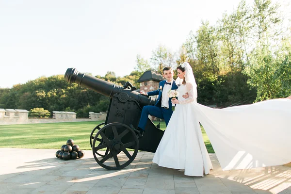 Young caucasian newly married couple near cannon — Stok fotoğraf