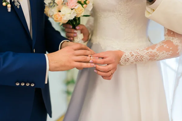 Νύφη βάζοντας ένα δαχτυλίδι για γαμπρούς δάχτυλο κατά τη διάρκεια της γαμήλιας τελετής — Φωτογραφία Αρχείου