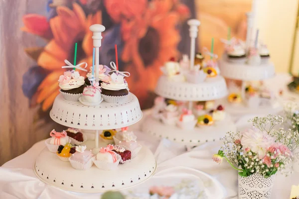 Piatto bianco di deliziosi cupcake colorati sulla tavola nuziale — Foto Stock