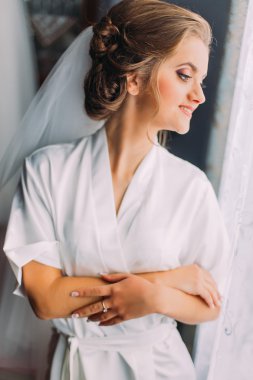 Güzel sarışın gelin hazırlık evlilik elbise ve pencere, poz gülümseyen peçe