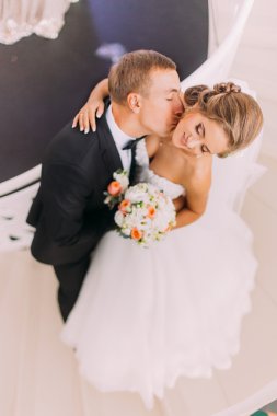 Yakışıklı damat onun güzel gelin yakın öper. Üstte görüntü