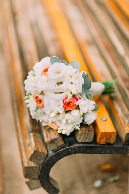 Beautiful summer bridal bouquet lying on a park bench
