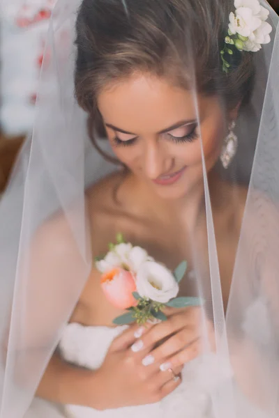 Close up retrato de noiva loira elegante feliz em vestido branco de luxo com buquê sob o véu — Fotografia de Stock