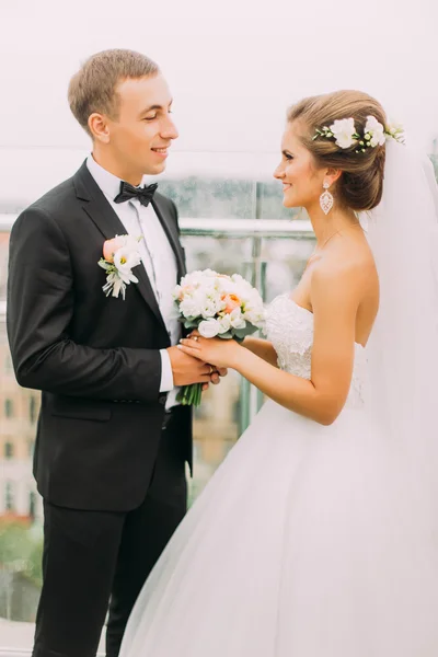 Щаслива подружня пара наречена і наречена тримаються за руки з букетом на балконі крупним планом — стокове фото