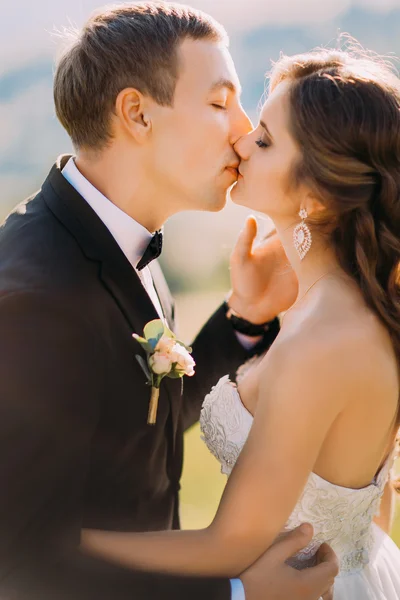 Vacker lycklig ung brud kysser stilig brudgummen närbild — Stockfoto