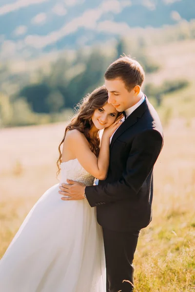 Stylish attractive happy bride and handsome groom lovely hugging outdoors — Stock Photo, Image