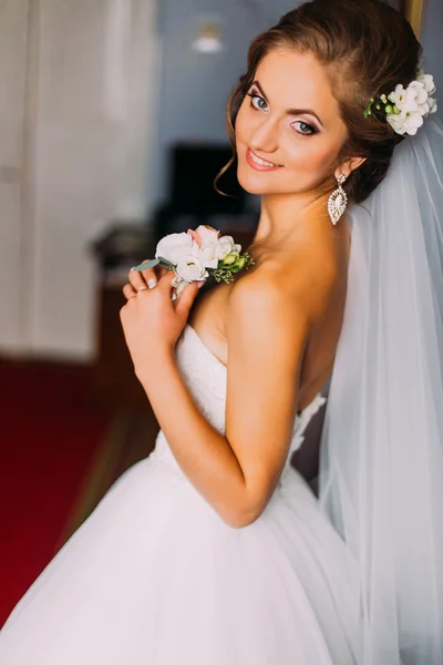 Beauty bride in bridal gown with hairstyle and bouquet indoors. Stock Picture