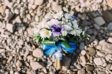 Stouns üzerinde beyaz ve menekşe çiçekleri ile bir düğün buketi yakın çekim