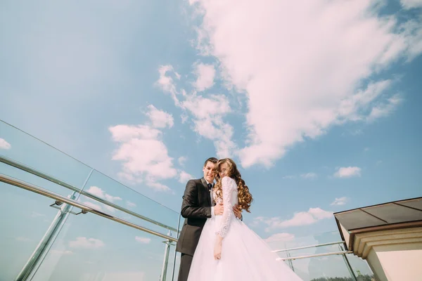 若い新郎新婦キス雲と青い空を背景 — ストック写真